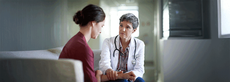 mujer preocupada hablando con médico en centro de reproducción asistida